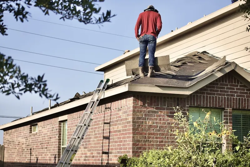 Professional roofer working on a residential roof in Woods of Wimbledon